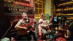 Enchanting scene: Two musicians singing with guitar and banjo, performing traditional Irish music.. One of the Premier Venues in Temple Bar Dublin.