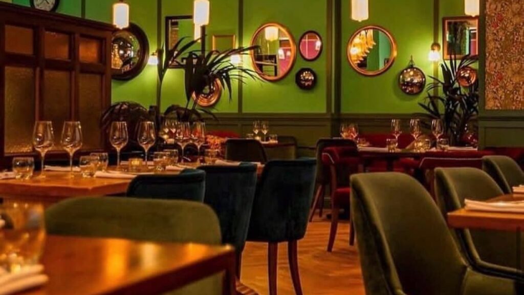 Chequer Lane restaurant interior with green walls, velvet seating, and elegant table settings, ideal for Christmas lunch in Dublin