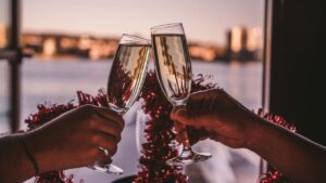 A hand shot of 2 People toasting champagne in front of a window with a lake in the background. A great offer if seeking Valentines Dinner in Dublin..