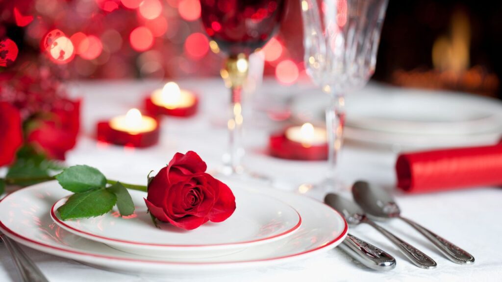 Table set in Sole Seafood Restaurant with white table cover and dressed with plates, cutlery and glasses. A red rose sits on one of the plates with small candles scattered over the table. One of the many venues with Valentines day offers in Dublin.