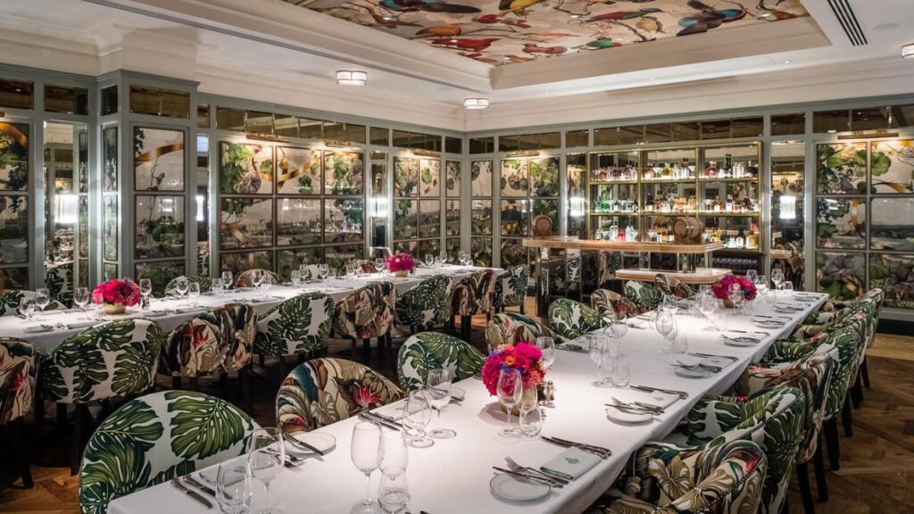 Christmas dinner in Dublin at The Ivy Dawson Street – private dining room with floral chairs, long white tablecloths, elegant décor, and a feature mirrored bar.