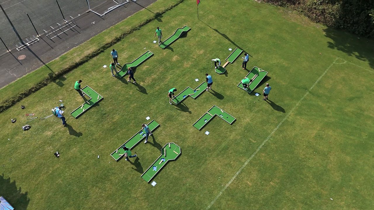 Crazy golf activity during a corporate retreat in Ireland Corporate retreats in Ireland featuring crazy golf in a large green open space
