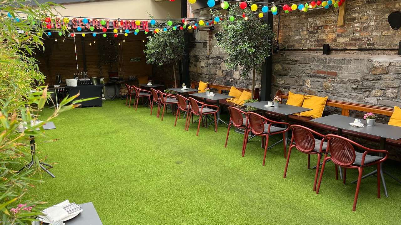 Outdoor area with decorative lighting at a summer party venue in Dublin Cosy outdoor party space with greenery, side tables, and decorative lighting at a summer party venue in Dublin