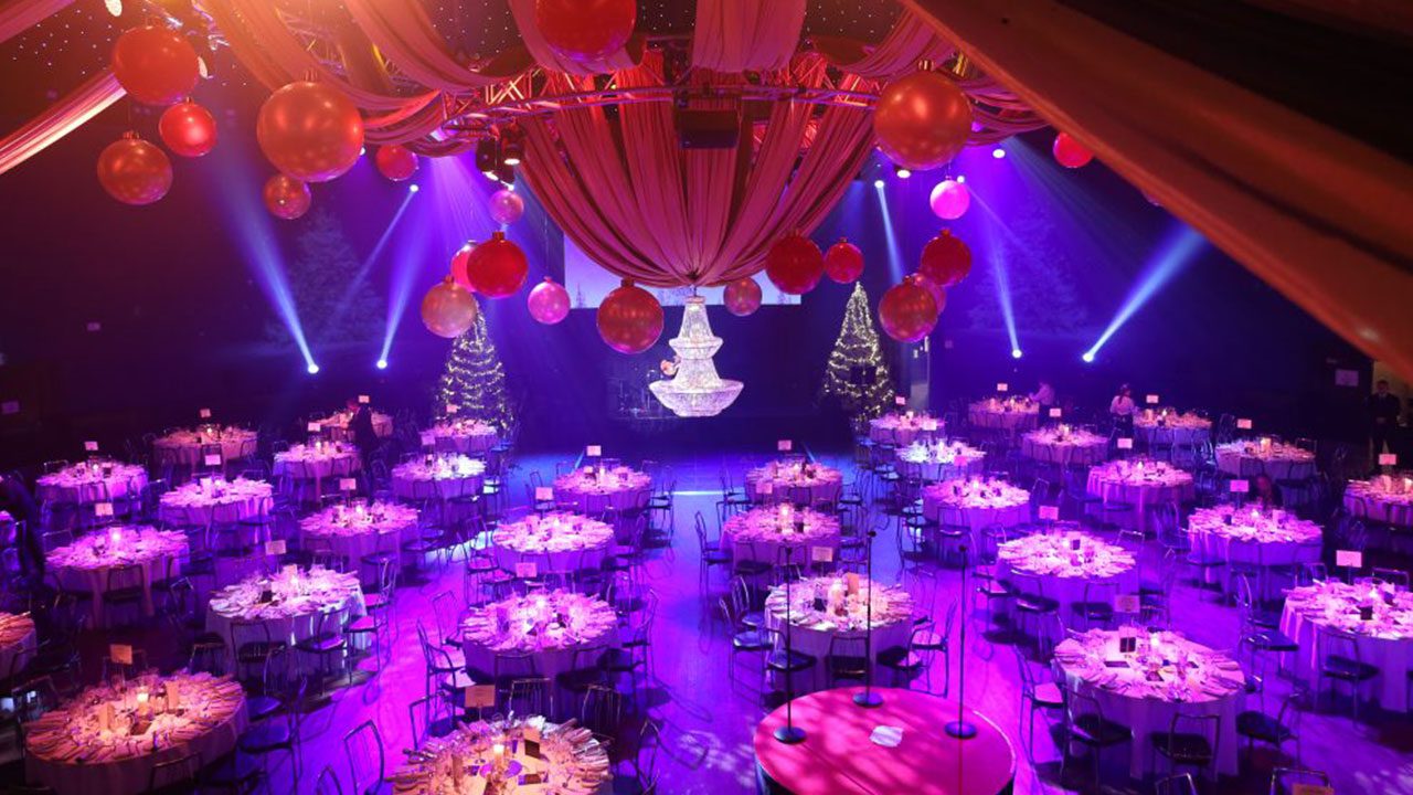 Gala dinner setup at a Christmas Party Night in Dublin Christmas Party Nights in Dublin with elegant round-table gala dinner setup and impressive lighting