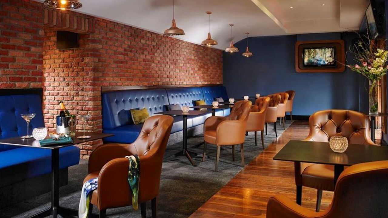 Cosy lounge with brick walls, blue banquette seating, and leather chairs for private party venues in Dublin