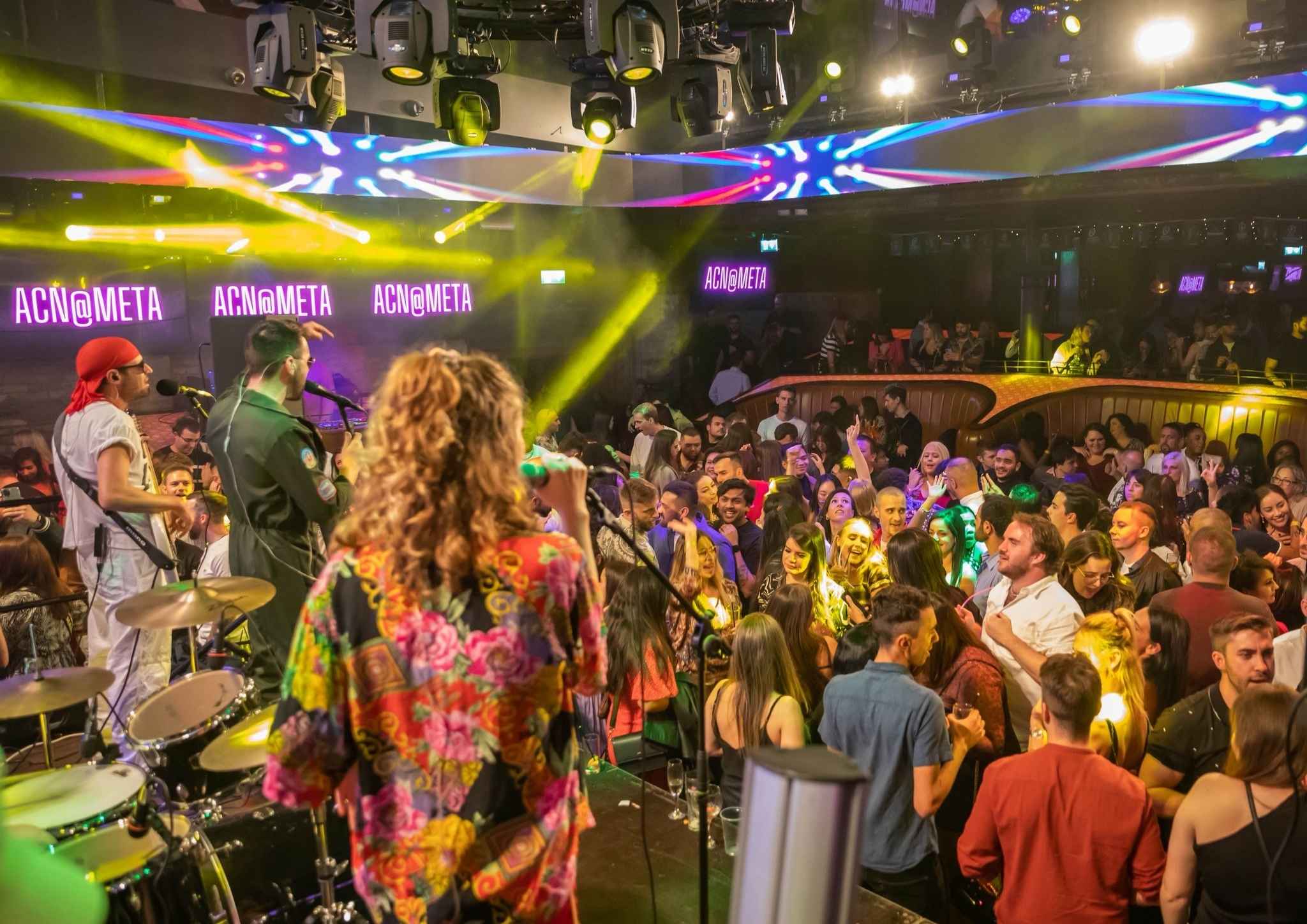 Live band performing at a busy corporate Christmas party night in Dublin with guests dancing and entertainment lighting throughout the venue.