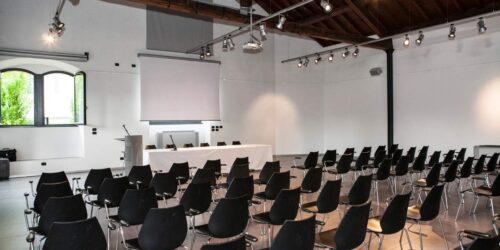 Modern conference venue in Dublin with large presentation screen, rows of chairs set for delegates, and full AV setup for corporate events.